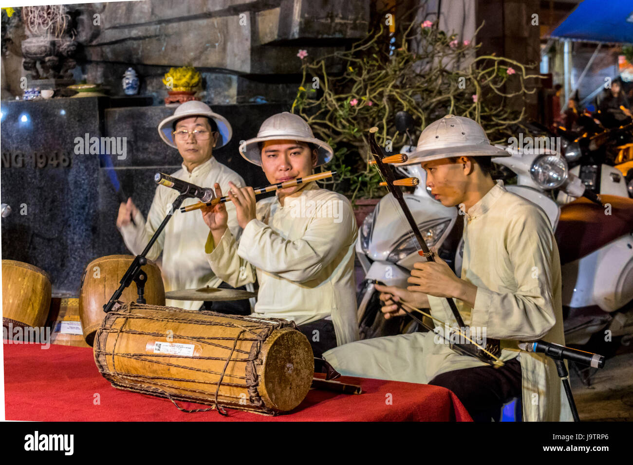 Musicians entertaining visitors shopping at the night market at Hanoi Vietnam Stock Photo