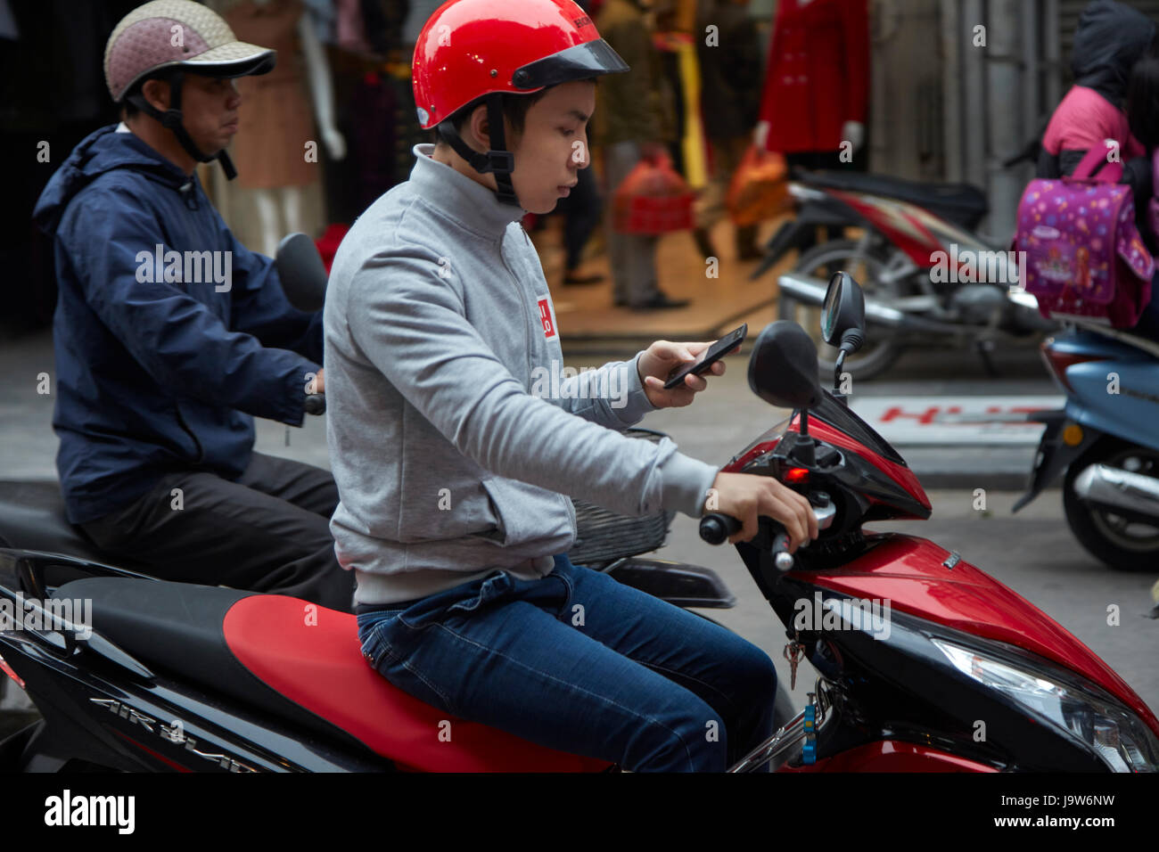 Man on cellphone riding scooter, Old Quarter, Hanoi, Vietnam Stock Photo