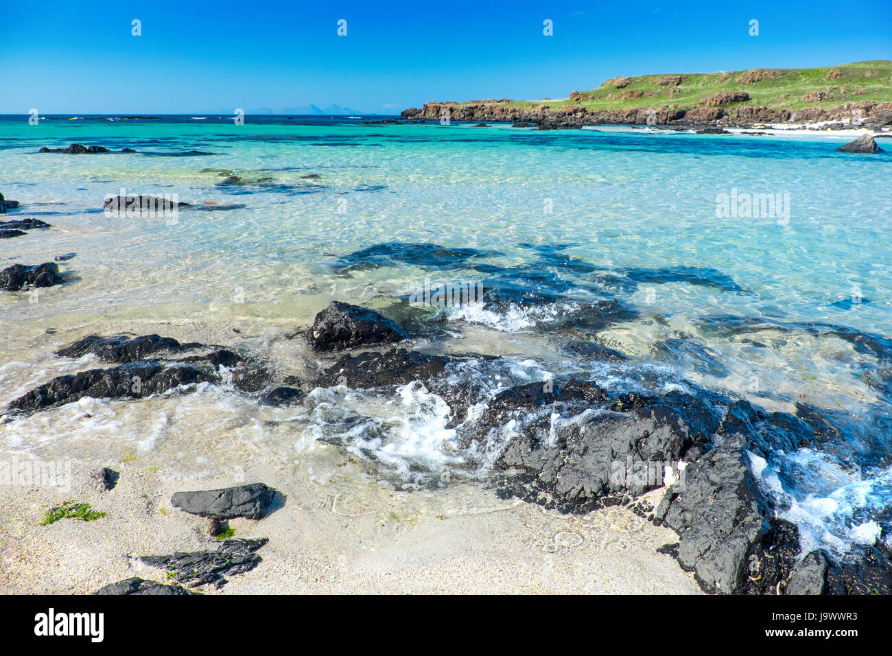 Crystal clear waters and white sand at Langamull beach on the north coast of Mull in the Scottish Hebrides Stock Photo