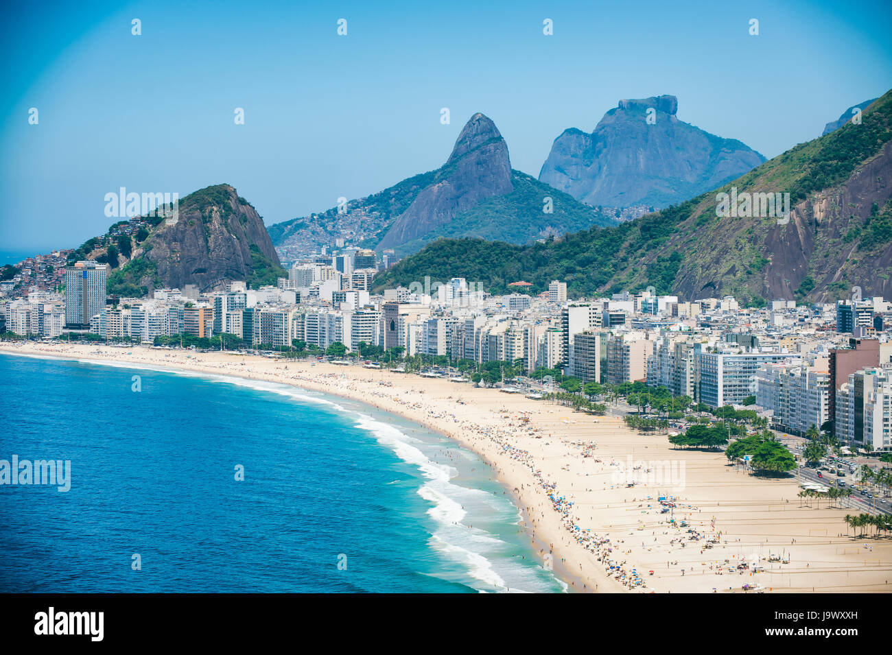 Bright scenic view of the Rio de Janeiro, Brazil skyline overlooking the shore of Copacabana Beach and dramatic mountains in the background Stock Photo