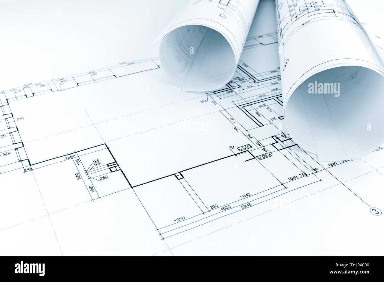 floor plan drawing with rolls of architectural blueprints Stock Photo