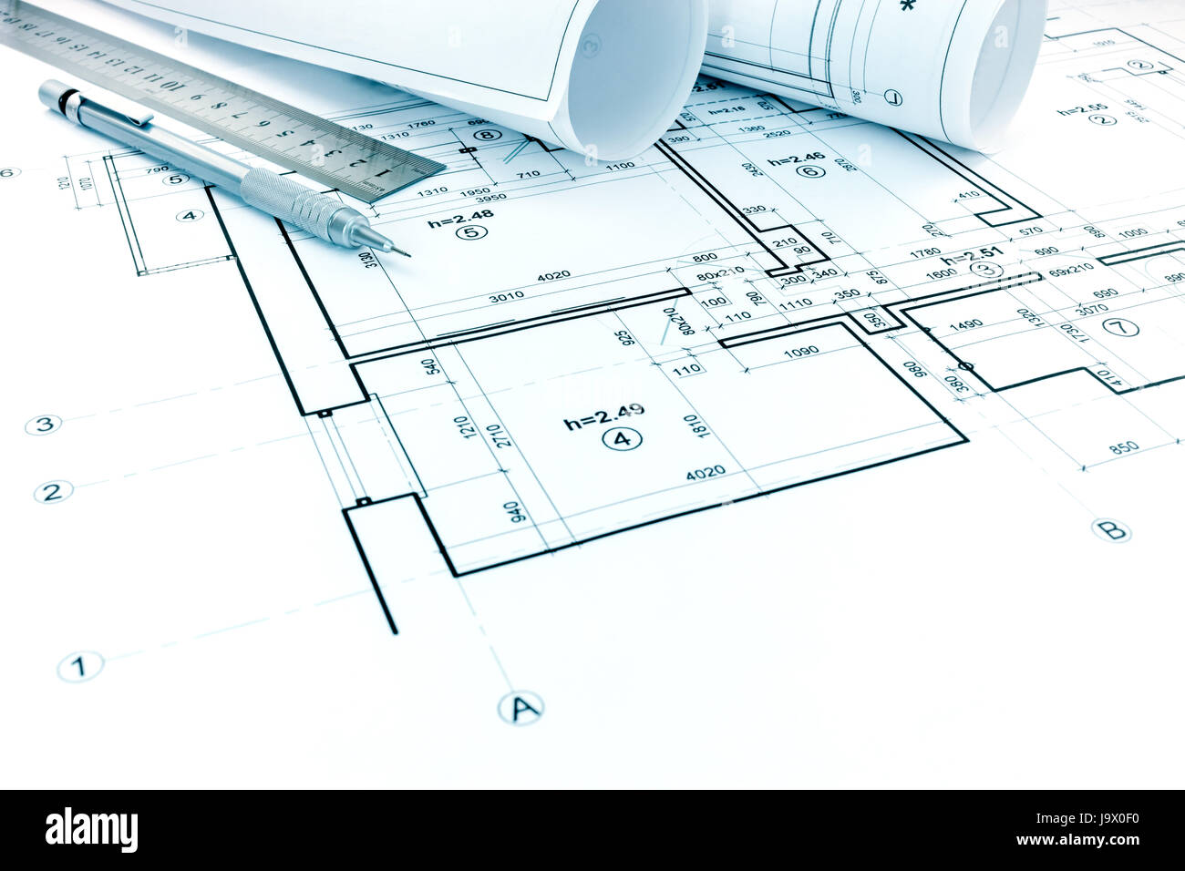 rolls of plans, drawing and measurement tools on architectural project of house Stock Photo