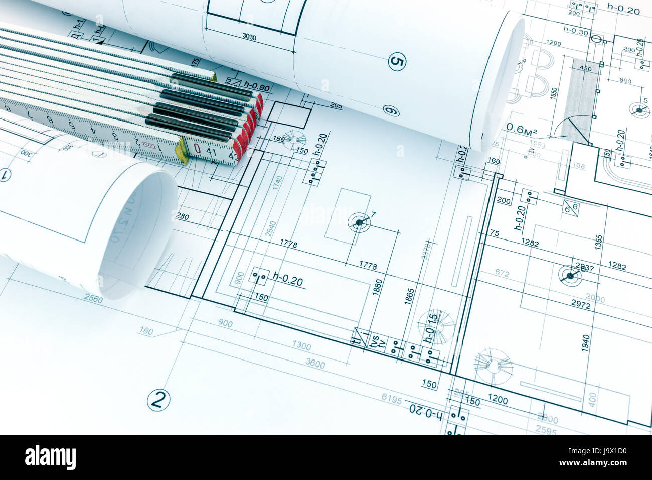 architectural project drawing with rolled blueprints and folding ruler ...