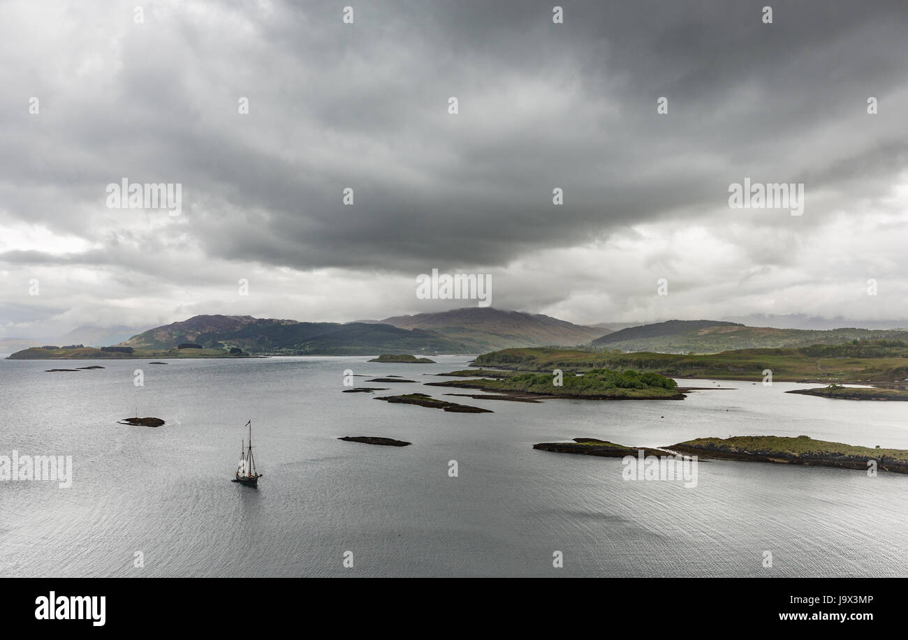 Wide angle image taken from Lismore of an old sailing ship moored in Loch Linnhe, Scotland with a dramatic overcast sky Stock Photo