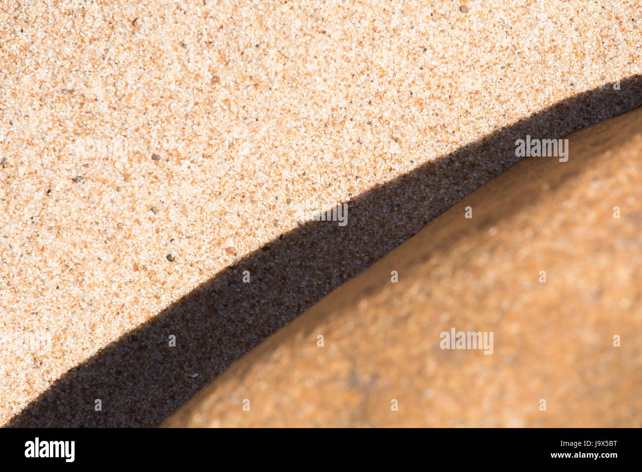 An abstract background of a sea sand and rock shapes. Shallow depth of field. Stock Photo