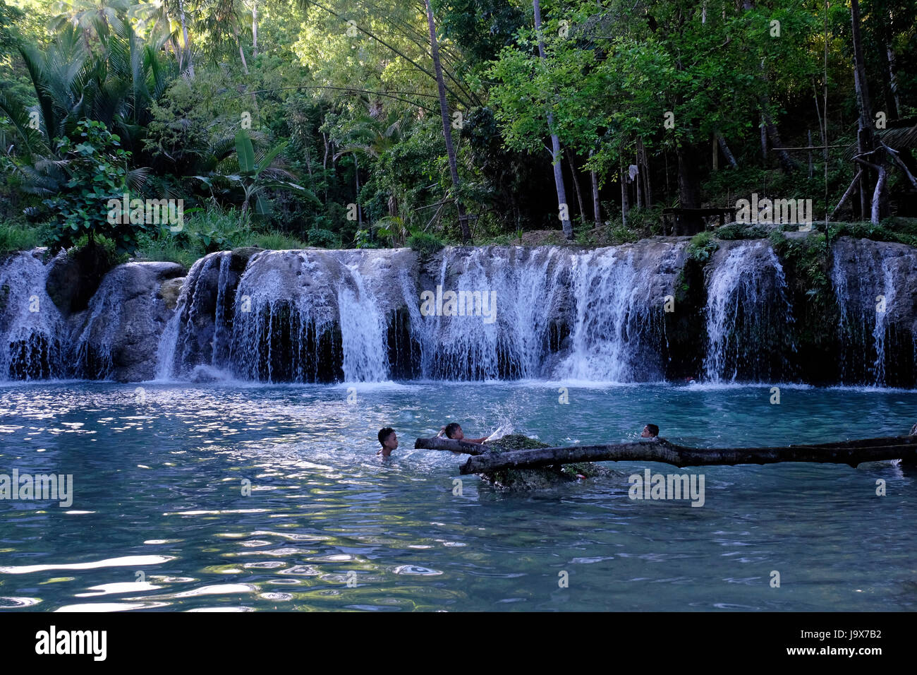 Locals bath at the Cambugahay Falls situated outside the town of Lazi in the island of Siquijor located in the Central Visayas region of the Philippines Stock Photo