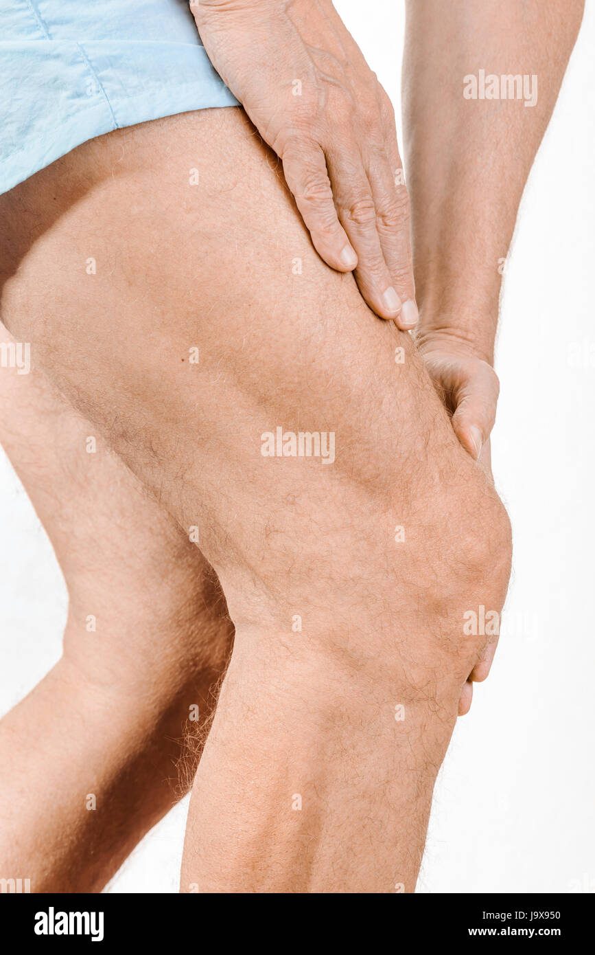 Athlete man massaging a painful  quadriceps and the knee after a sport accident. It could be a musculaire claquage, a muscle elongation, a medial meni Stock Photo