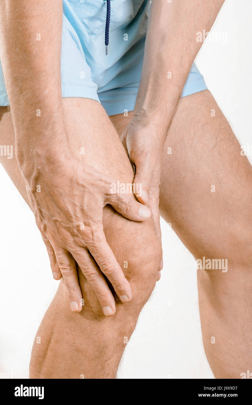 Athlete man feeling pain to the knee and the quadriceps. It could be Iliotibial band syndrome or quadriceps tendinopathy Stock Photo