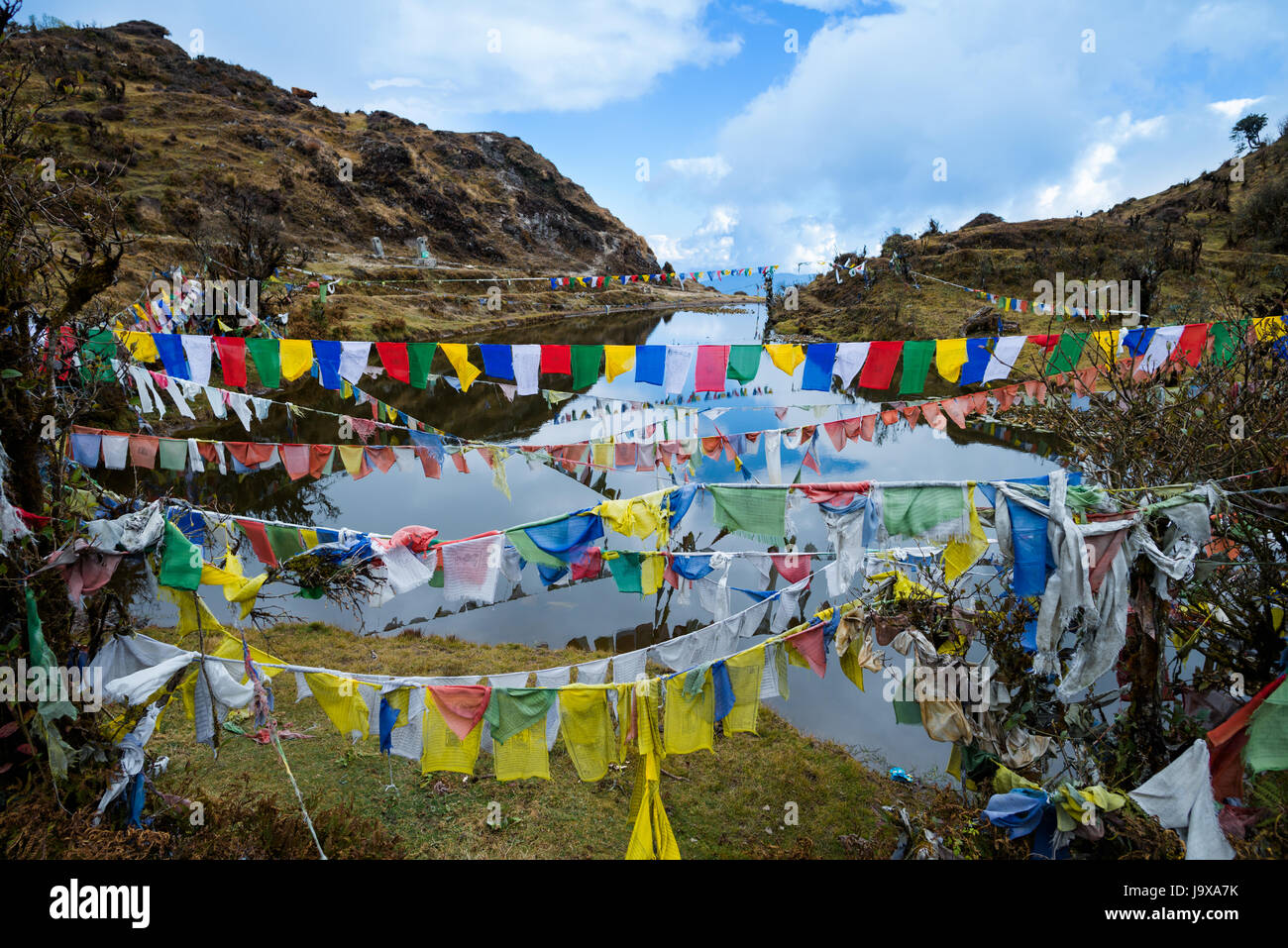 Lungta or prayer flags flung at Kala Pokhri, the Black Water Pond. They are to promote peace, strength, compassion, and wisdom Stock Photo