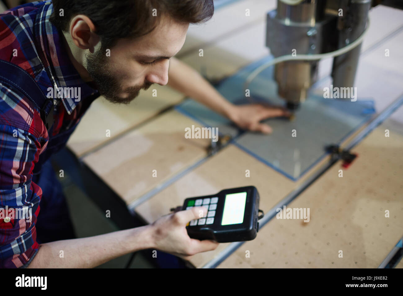 Master with electronic machine standing by workplace Stock Photo Alamy
