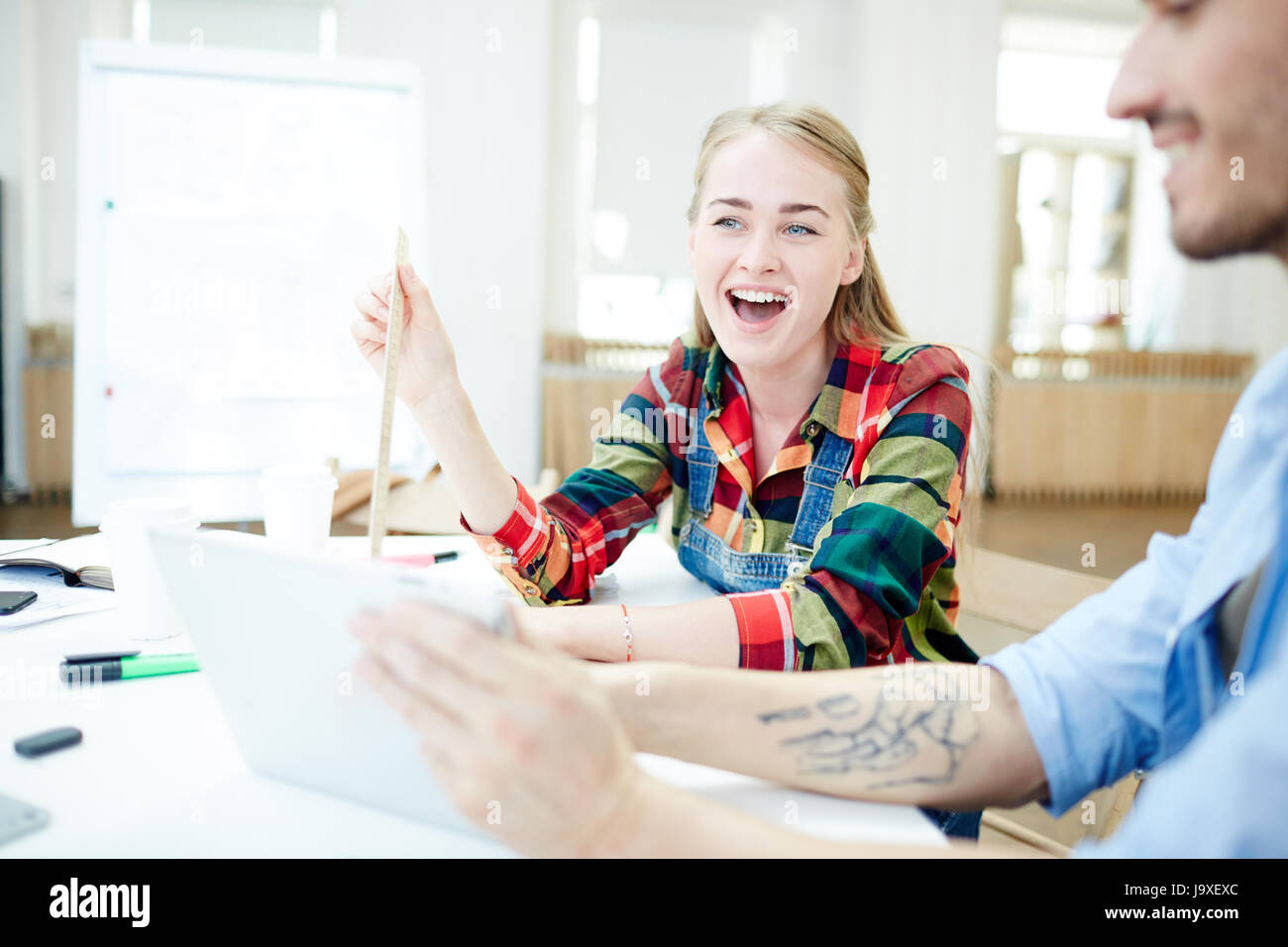 Pretty student laughing during discussion at lesson Stock Photo
