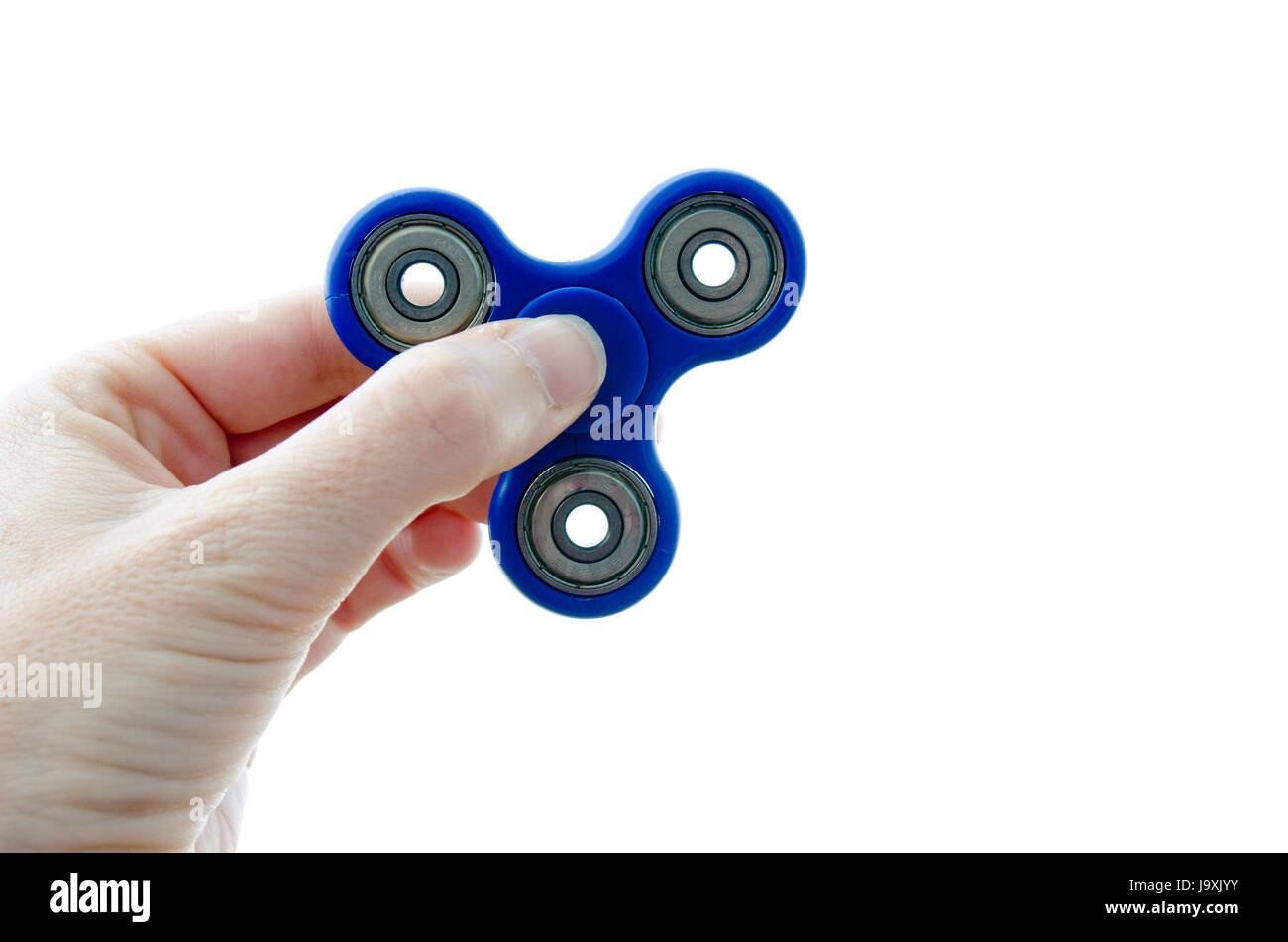 Hand holding up a blue fidget spinner against a white background Stock Photo