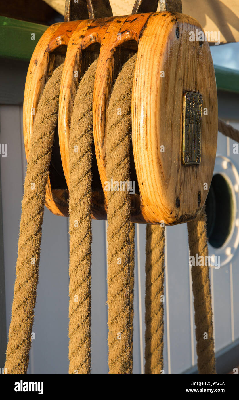 Block and tackle, pulley and rope on board an old sailing ship late in evening with a soft golden light Stock Photo