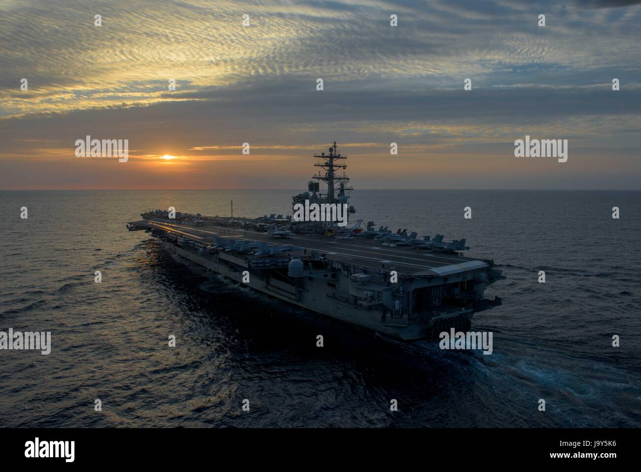 The USN Nimitz-class aircraft carrier USS Ronald Reagan steams underway at sunset May 27, 2017 in the Sea of Japan.    (photo by Nathan Burke /US Navy  via Planetpix) Stock Photo