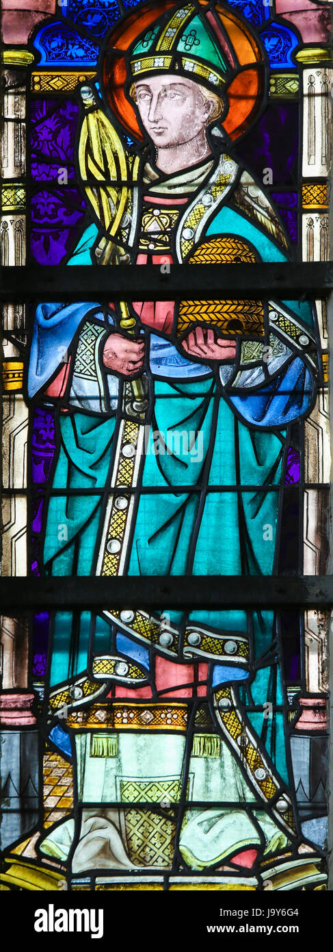 Stained Glass window in St Gummarus Church in Lier, Belgium, depicting Saint Ambrose or Ambrosius holding a beehive Stock Photo