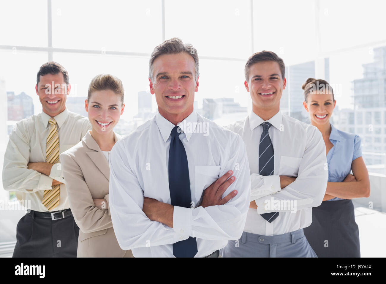 Smiling business people with arms crossed in their modern office Stock ...