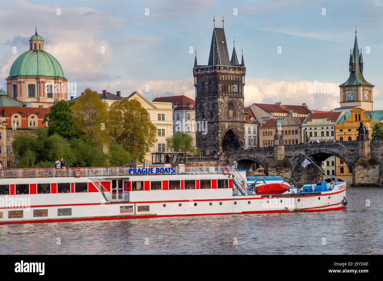 River cruise boat on the Vltava river in front of the Charles Bridge in Prague, Czech Republic Stock Photo