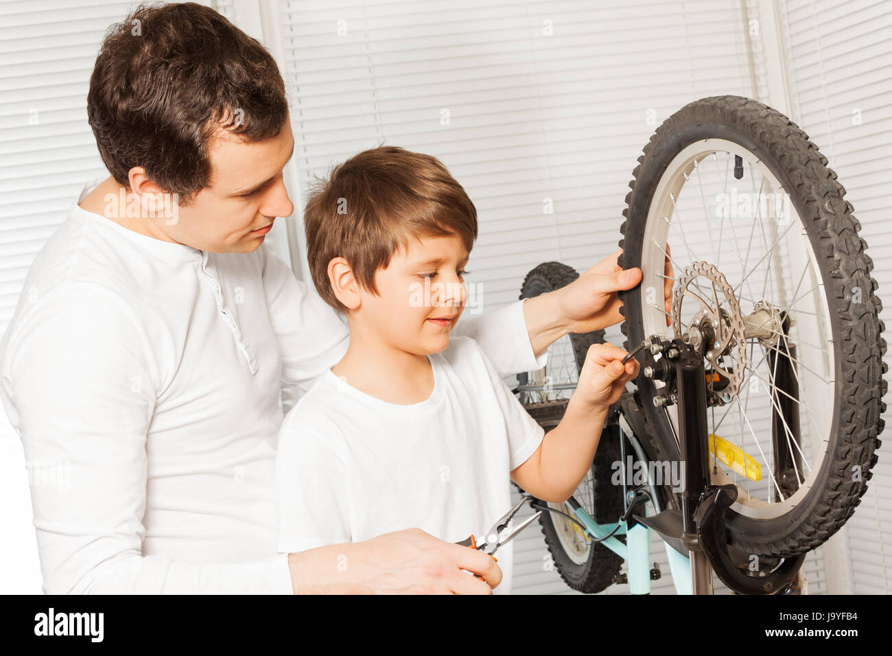Father with son replacing cable in bicycle brakes Stock Photo Alamy