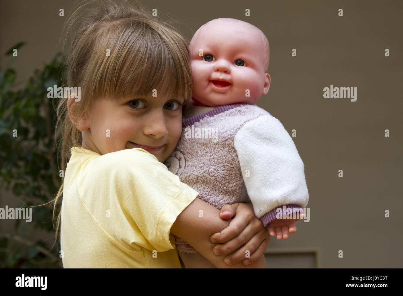 Cute smiling little girl embracing her baby doll toy Stock Photo - Alamy