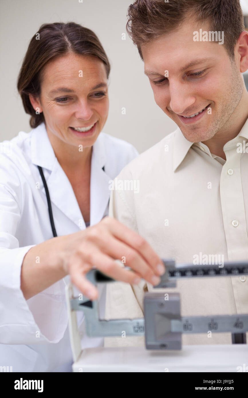 Doctor Using Measuring Tools Doctor helping patient with adjusting medical scale Stock Photo - Alamy