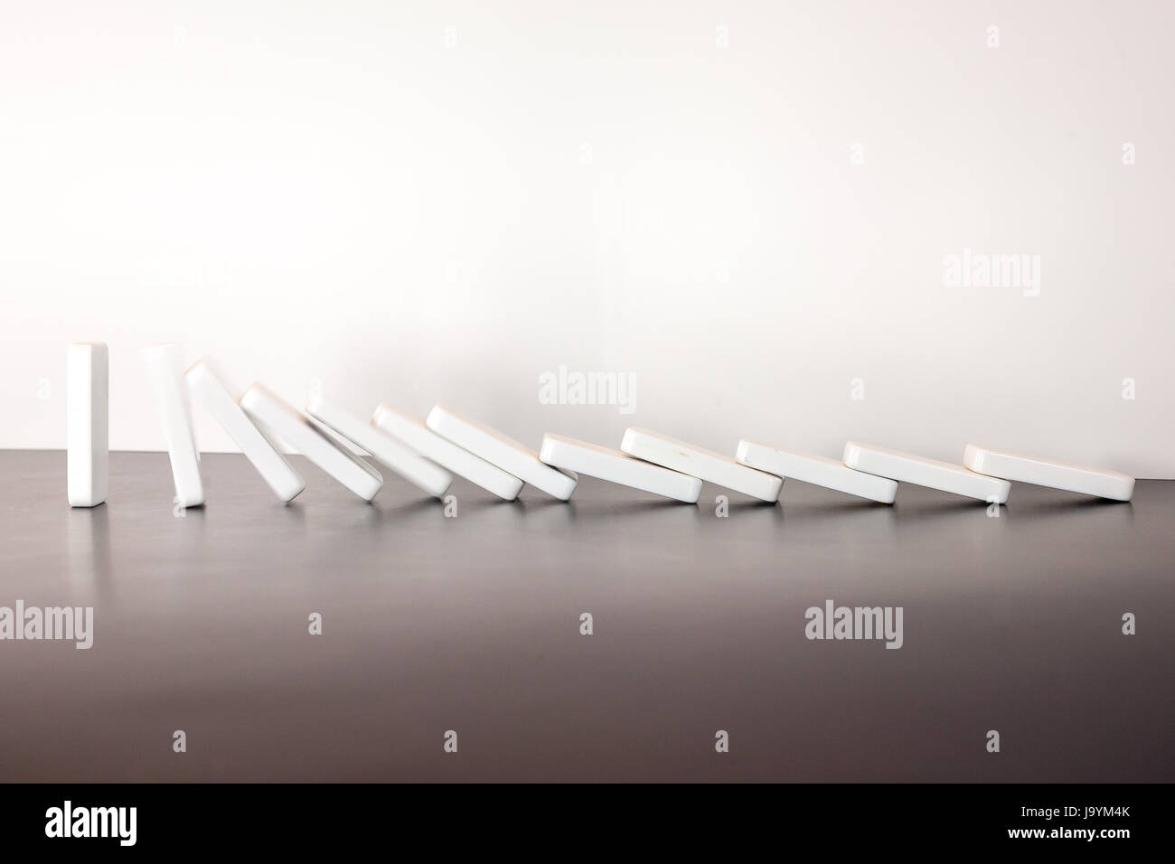 A row of falling dominos in motion. Stock Photo