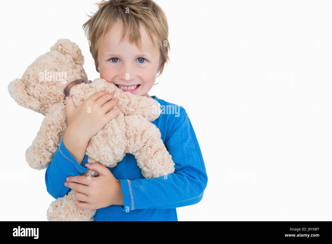 Portrait of happy young boy hugging teddy bear over white background ...