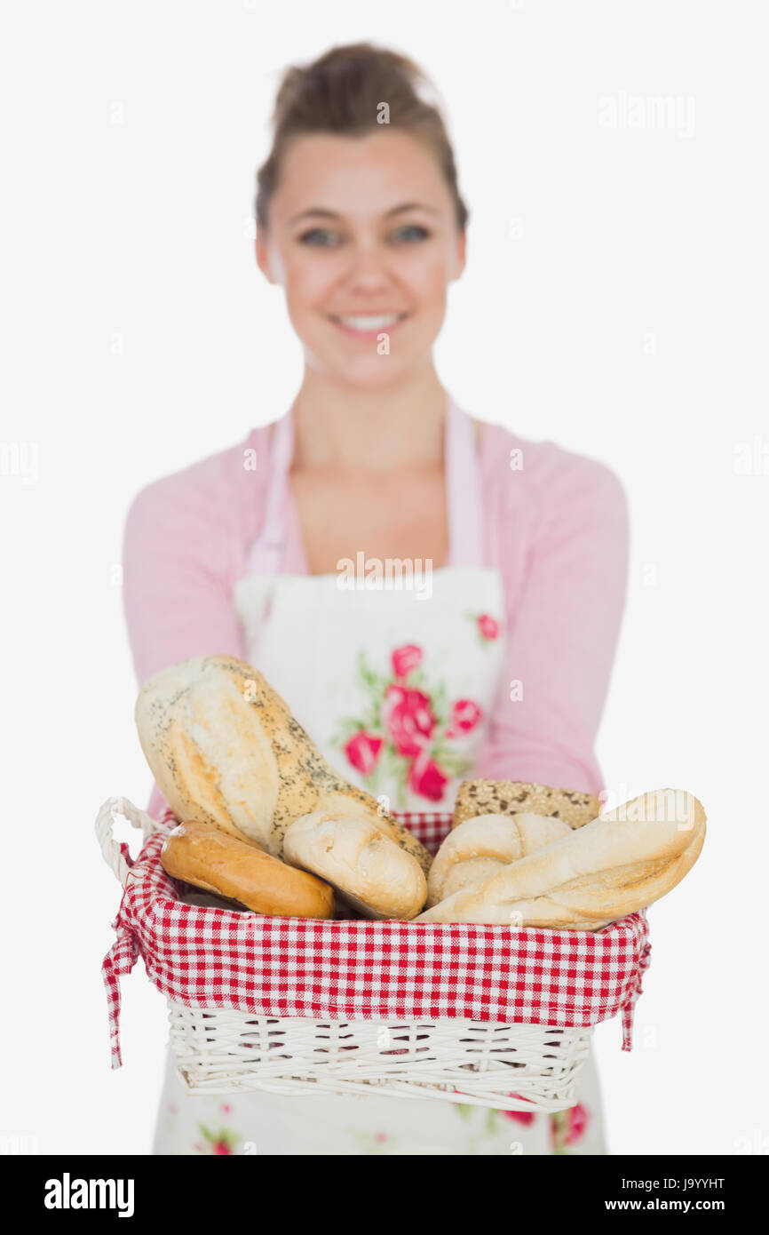 Portrait of happy young woman with bread basket against white