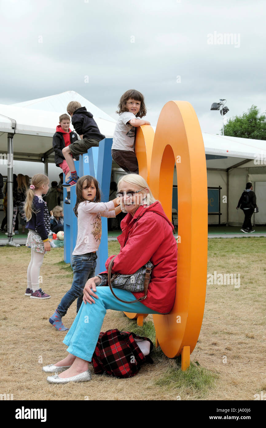 An elderly woman joins in with the kids on the Hay 30 Anniversary sign at the 2017 Hay Festival, Hay-on-Wye, Wales UK    KATHY DEWITT Stock Photo