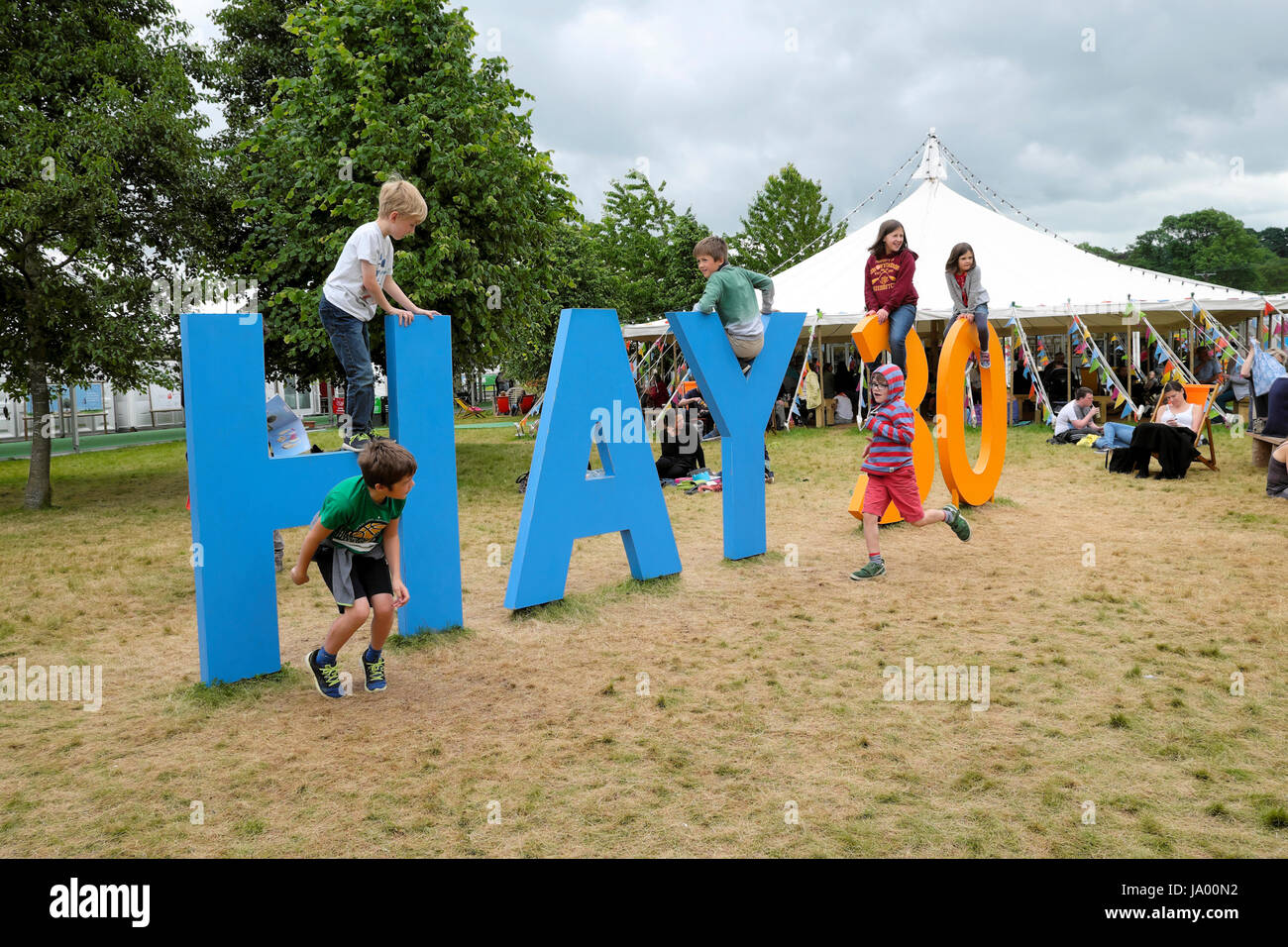 Kids playing outside climbing on the Hay 30 sign celebrating the 30th year of the Hay Festival, Hay-on-Wye, Wales UK    KATHY DEWITT Stock Photo