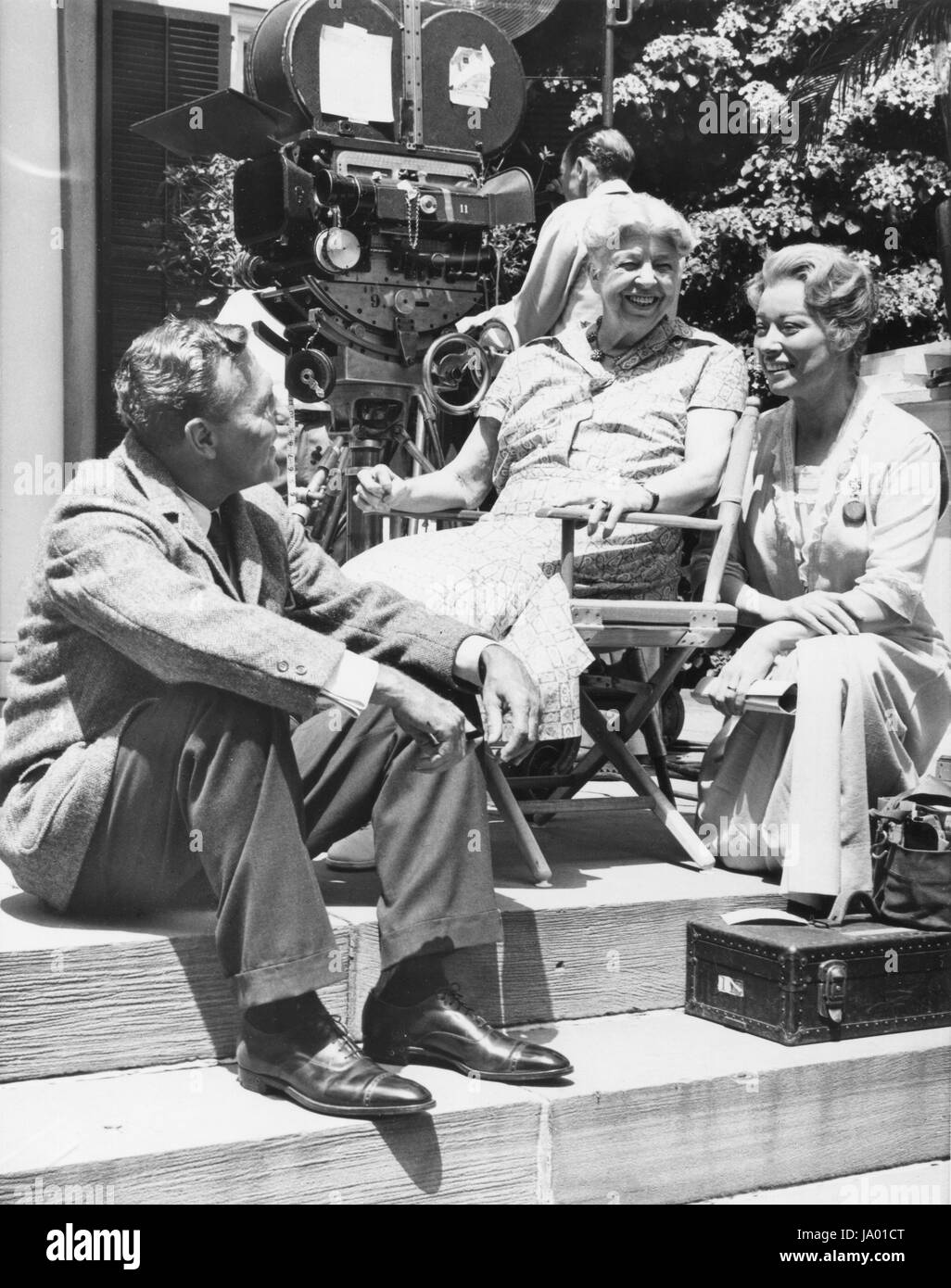 Ralph Bellamy, portraying Franklin D. Roosevelt, and Greer Garson (right), portraying Mrs. Eleanor Roosevelt, enjoy a chat with Mrs. Roosevelt at the Roosevelt family home during filming of 'Sunrise at Campobello,' Hyde Park, NY, 07/27/1960. Stock Photo