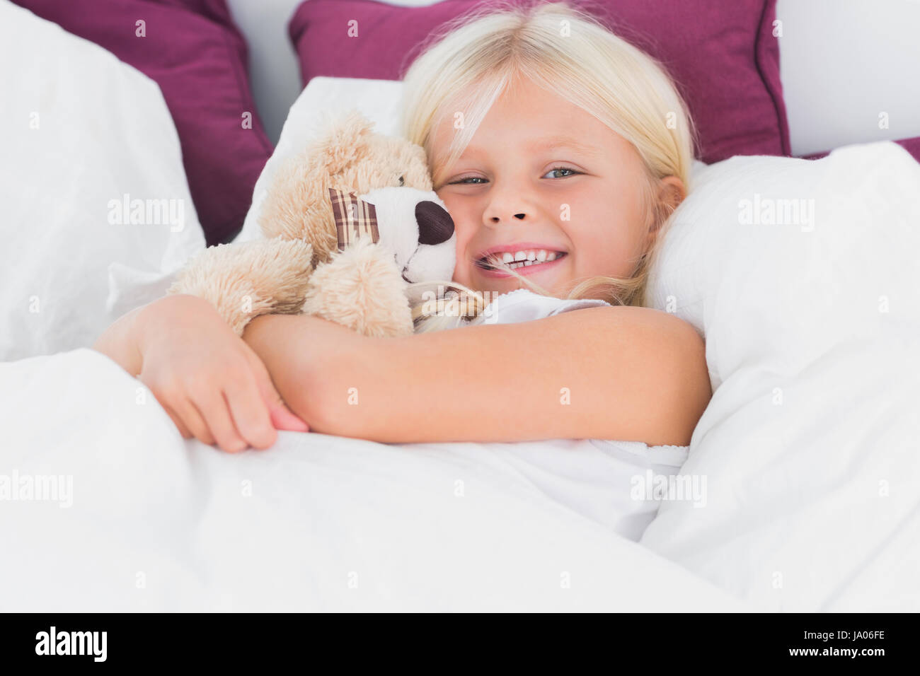 Little girl embracing her cuddly toy on the bed Stock Photo Alamy