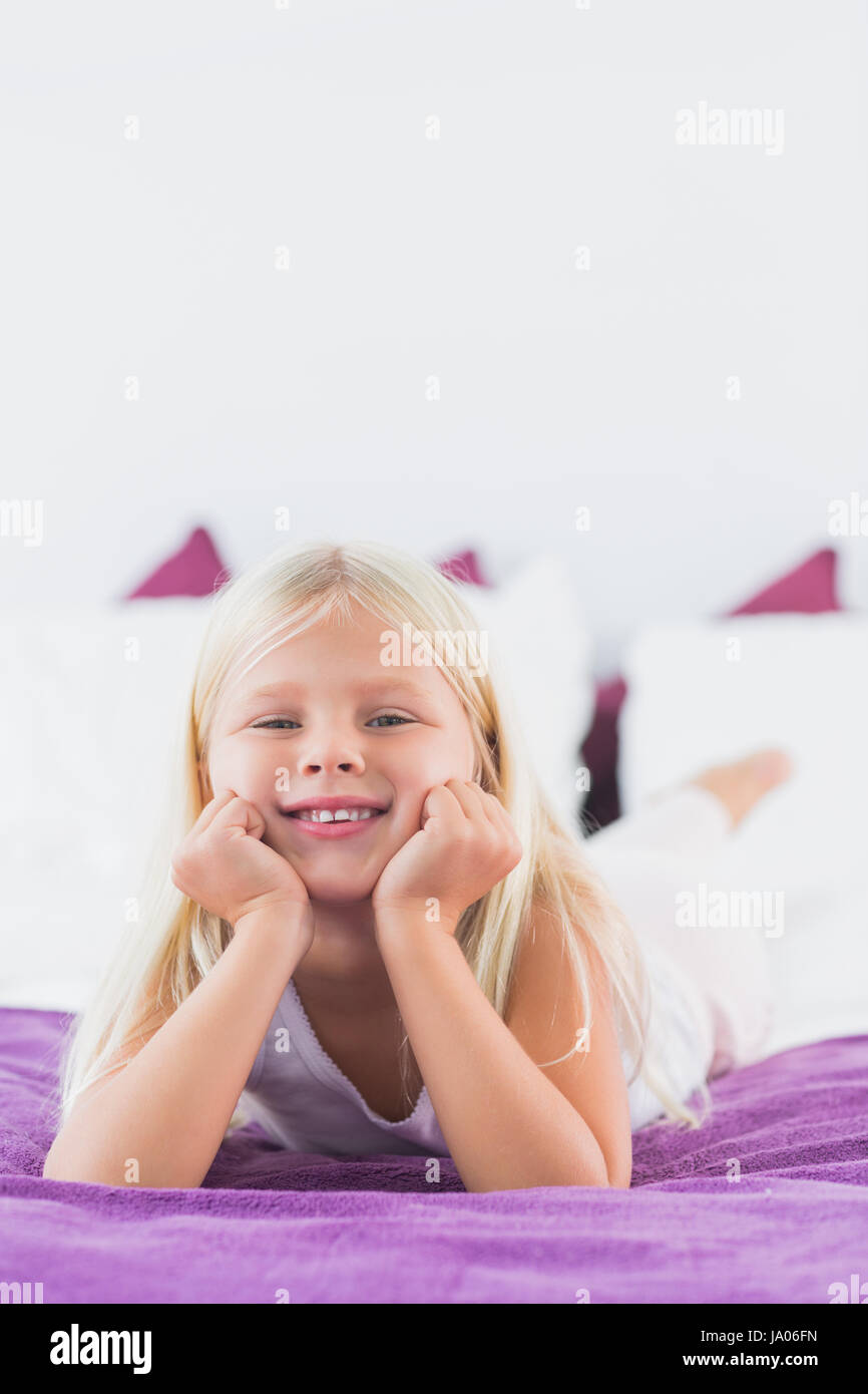 Little girl lying on a double bed in the bedroom Stock Photo Alamy