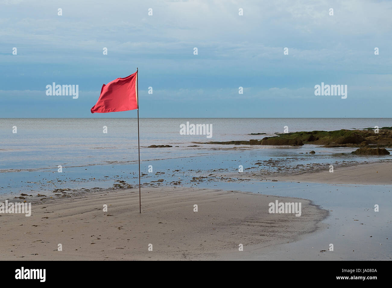 red flag on the beach in Uruguay Stock Photo
