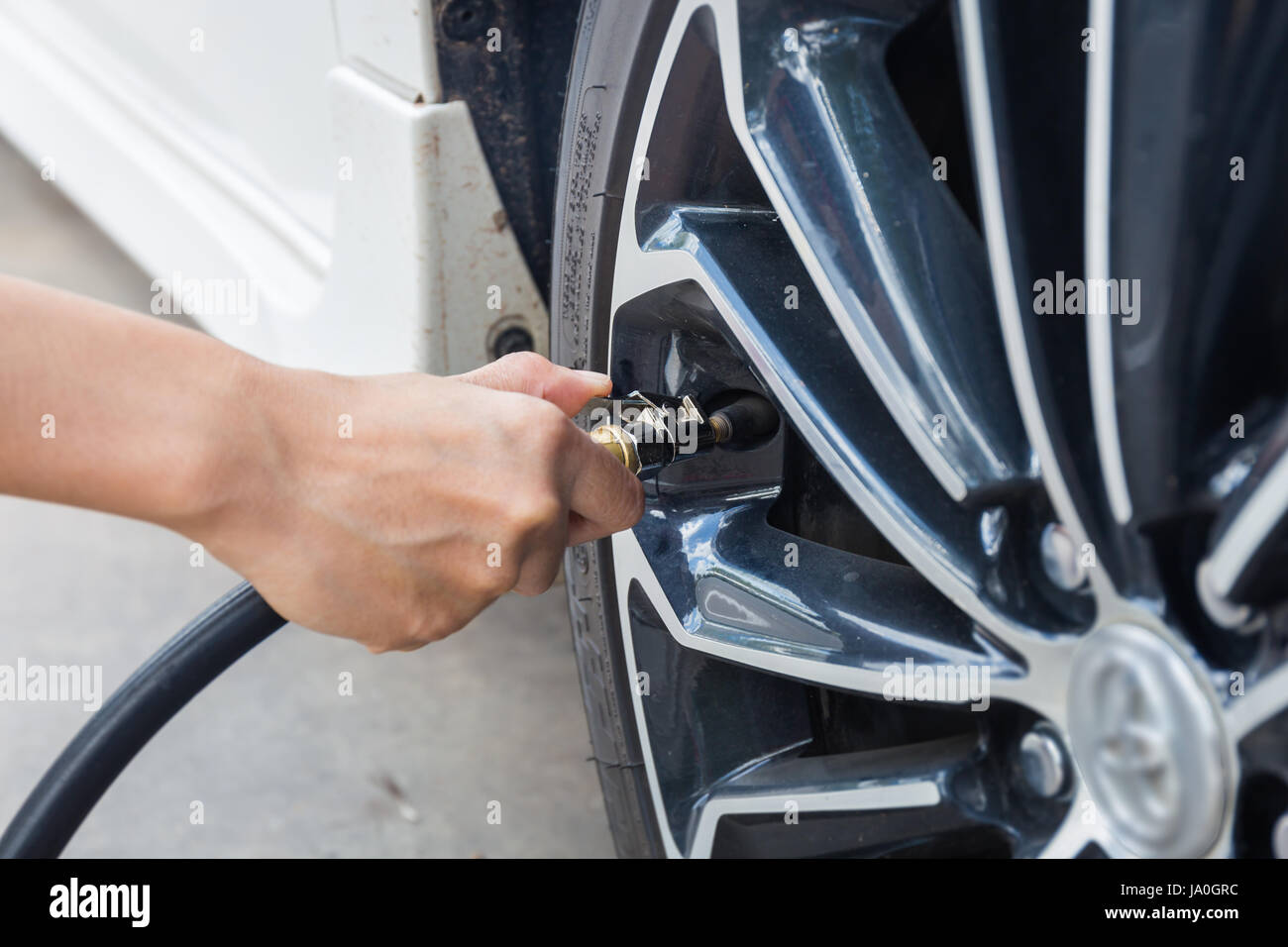 Man checking air pressure and filling air in the tires of car. Concept