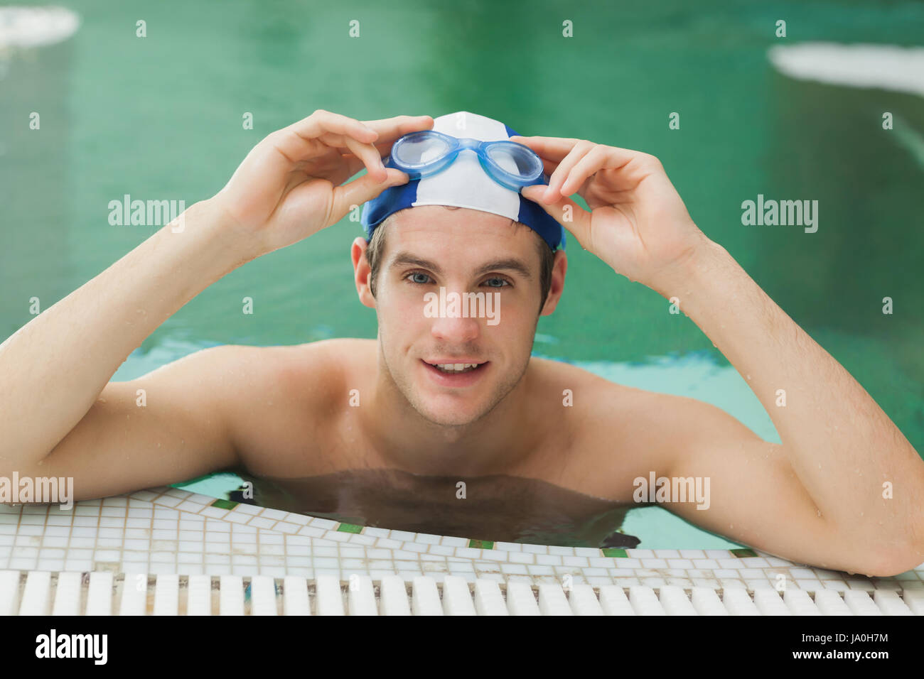 Man taking off his swimming goggles in the pool Stock Photo