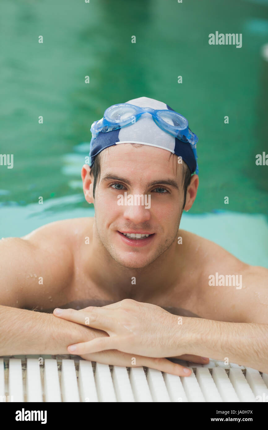 Happy man wearing goggles and cap in swimming pool Stock Photo