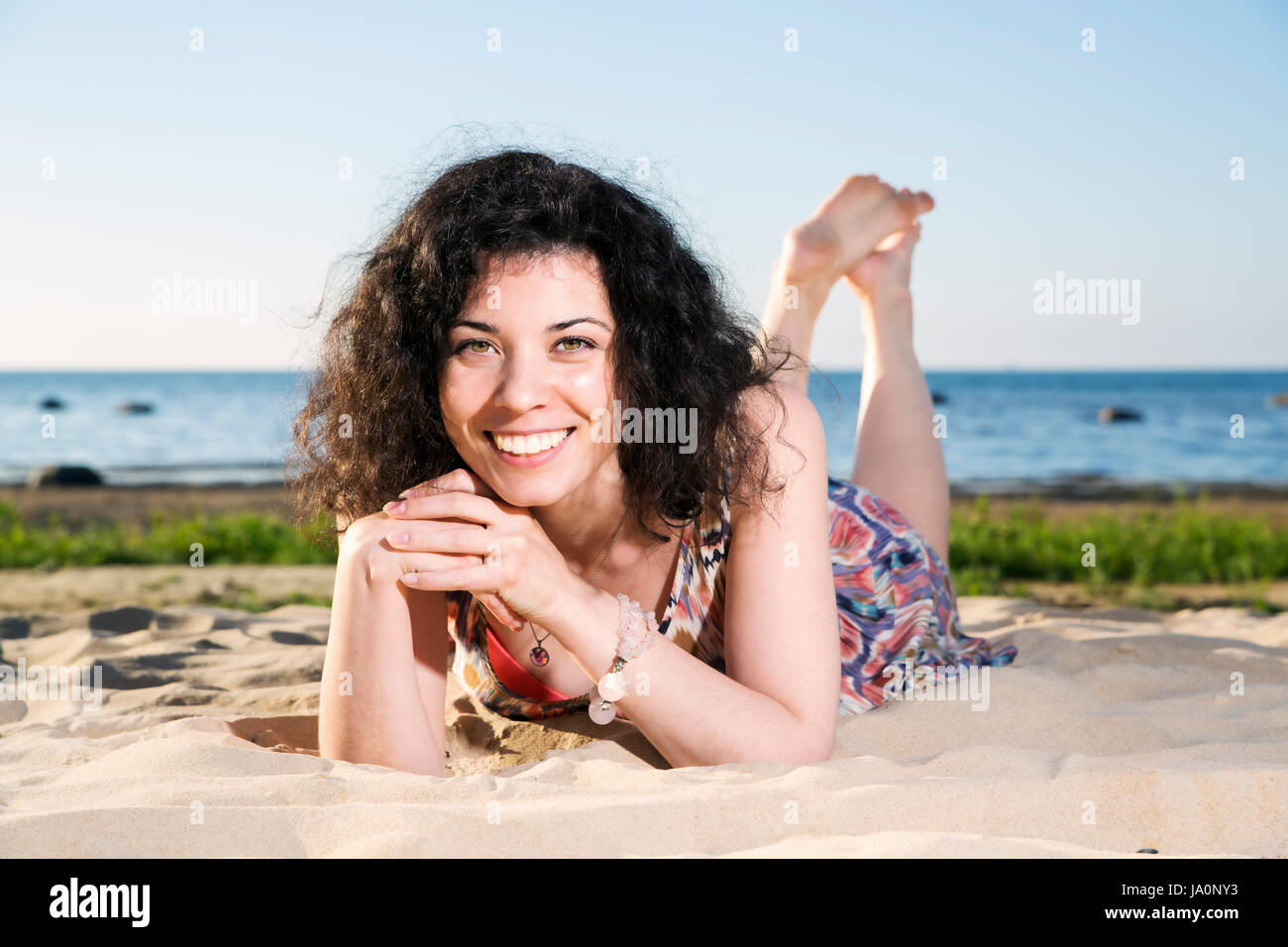 happy-woman-with-dark-hairs-lying-at-beach-hi-res-stock-photography-and