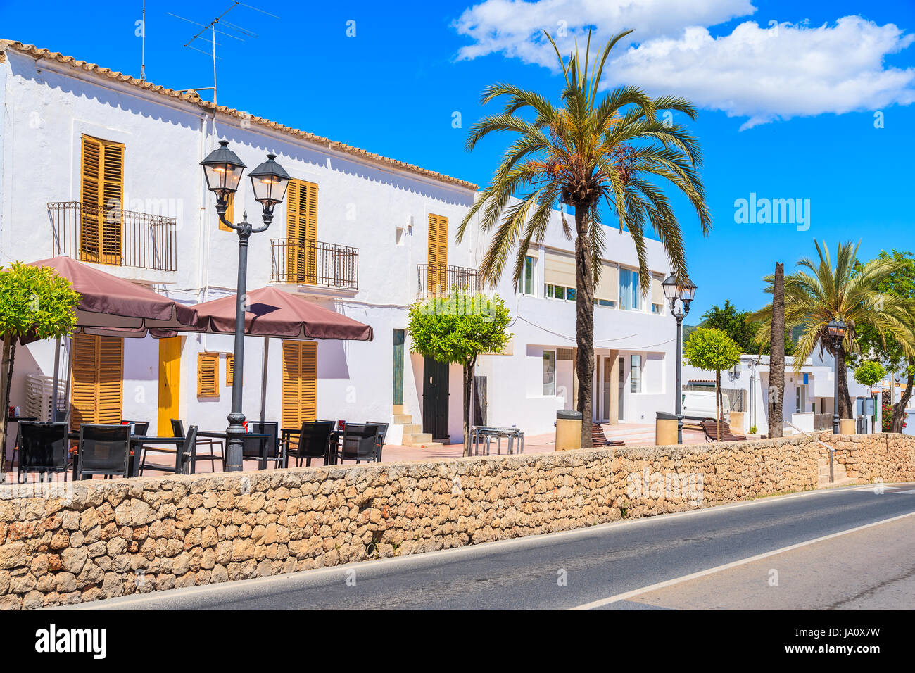 Typical Spanish style houses and palm tree on street of Sant Josep de sa Talaia town, Ibiza island, Spain Stock Photo