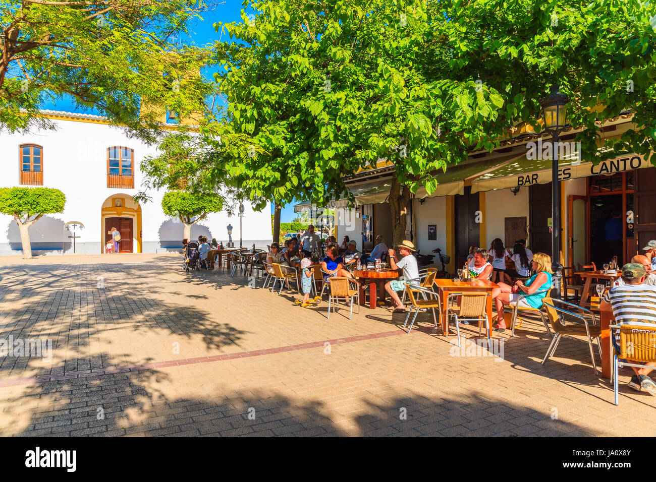 SANTA GERTRUDIS DE FRUTERA, IBIZA ISLAND - MAY 19, 2017: people sitting outdoors in restaurants on church square in Santa Getrudis town on Ibiza islan Stock Photo