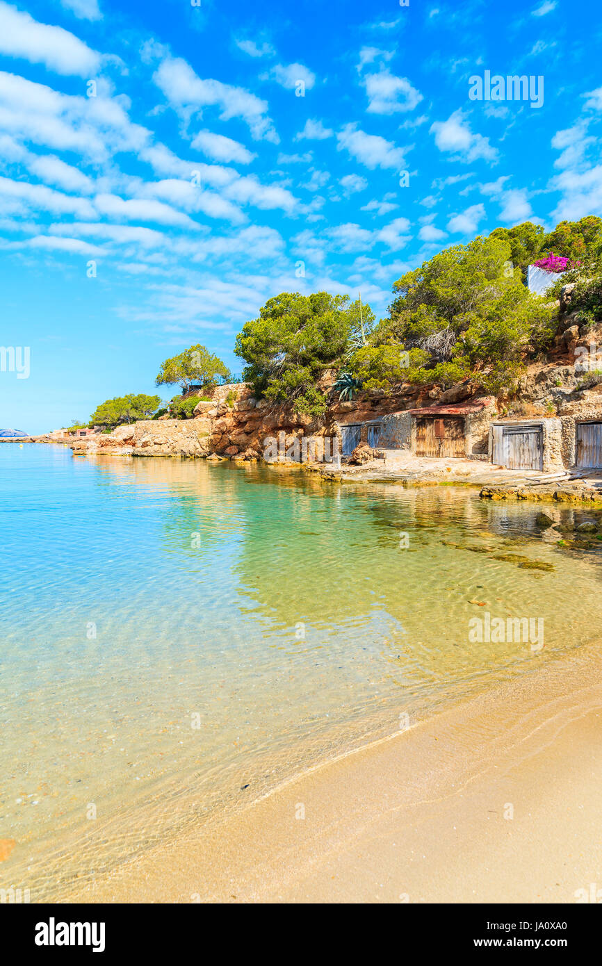 View of beautiful Cala Gracio beach with boat houses on shore at early