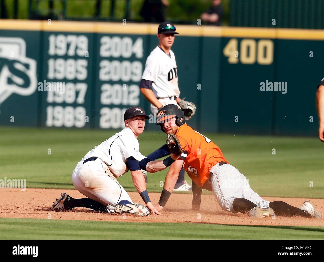 The Umpire For The Call. 3rd June, 2017. ORU second baseman Nick Roark #12 and OSU first baseman Michael Neustifter #15 both look back to the umpire for the call. The Oral Roberts Golden Eagles defeated the OSU Cowboys 14-6 at Baum Stadium in Fayetteville, AR, Richey Miller/CSM/Alamy Live News Stock Photo