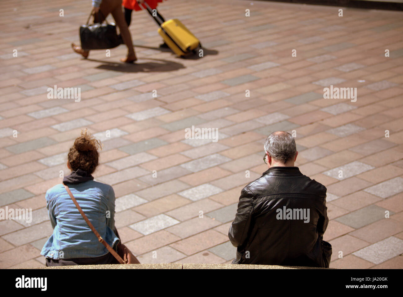 tourists on the streets of Glasgow Scotland sitting from behind dreams of leaving Stock Photo