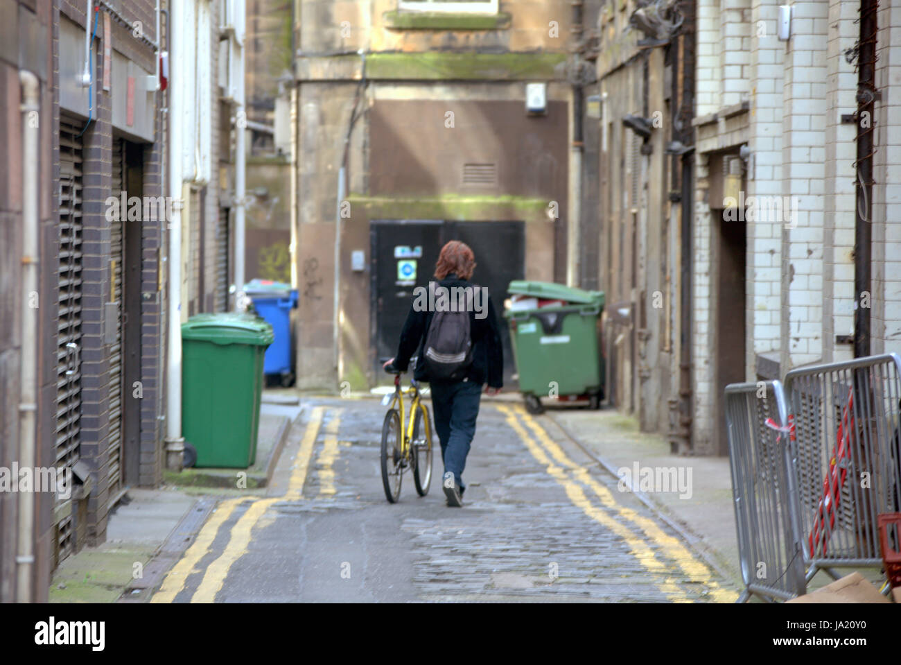 Glasgow alley backstreet lane with cyclist walking bike North Court Lane Stock Photo