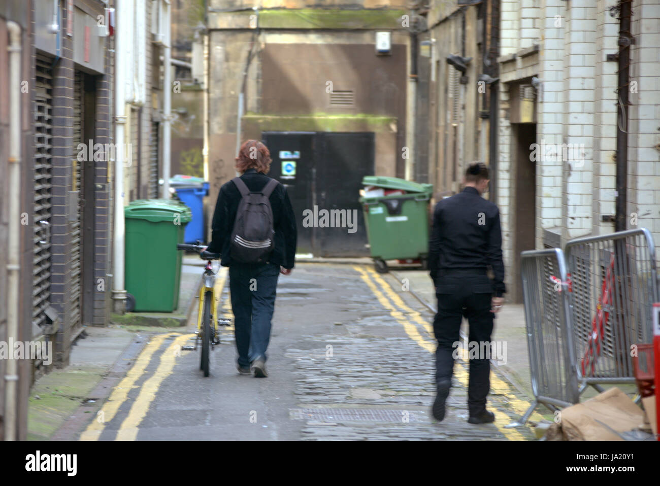 Glasgow alley backstreet lane with cyclist walking bike North Court Lane Stock Photo