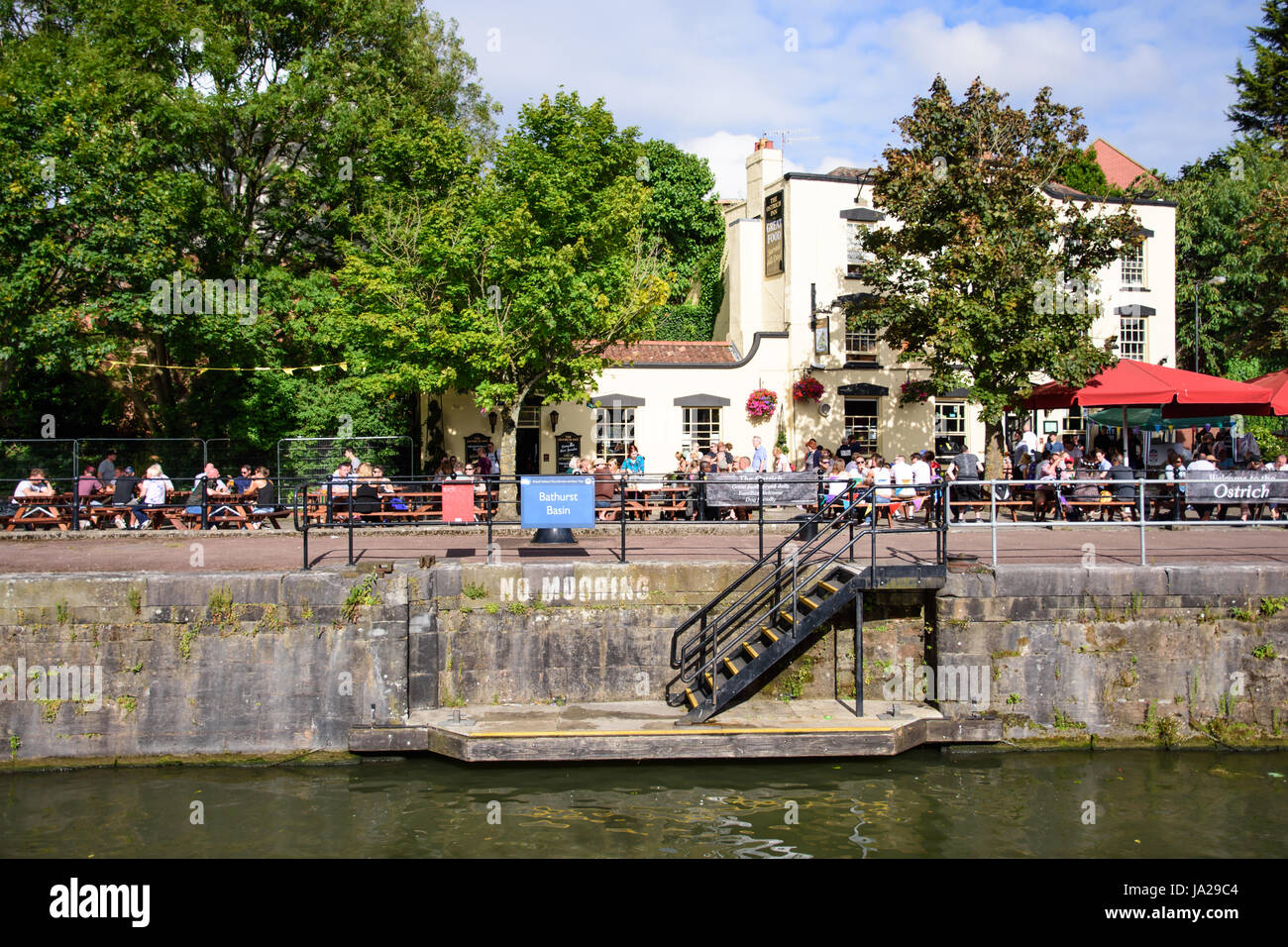 Bristol, England - July 17, 2016: Crowds and customers line the quayside of Bristol's Floating Harbour outside the Ostrich pub. Stock Photo
