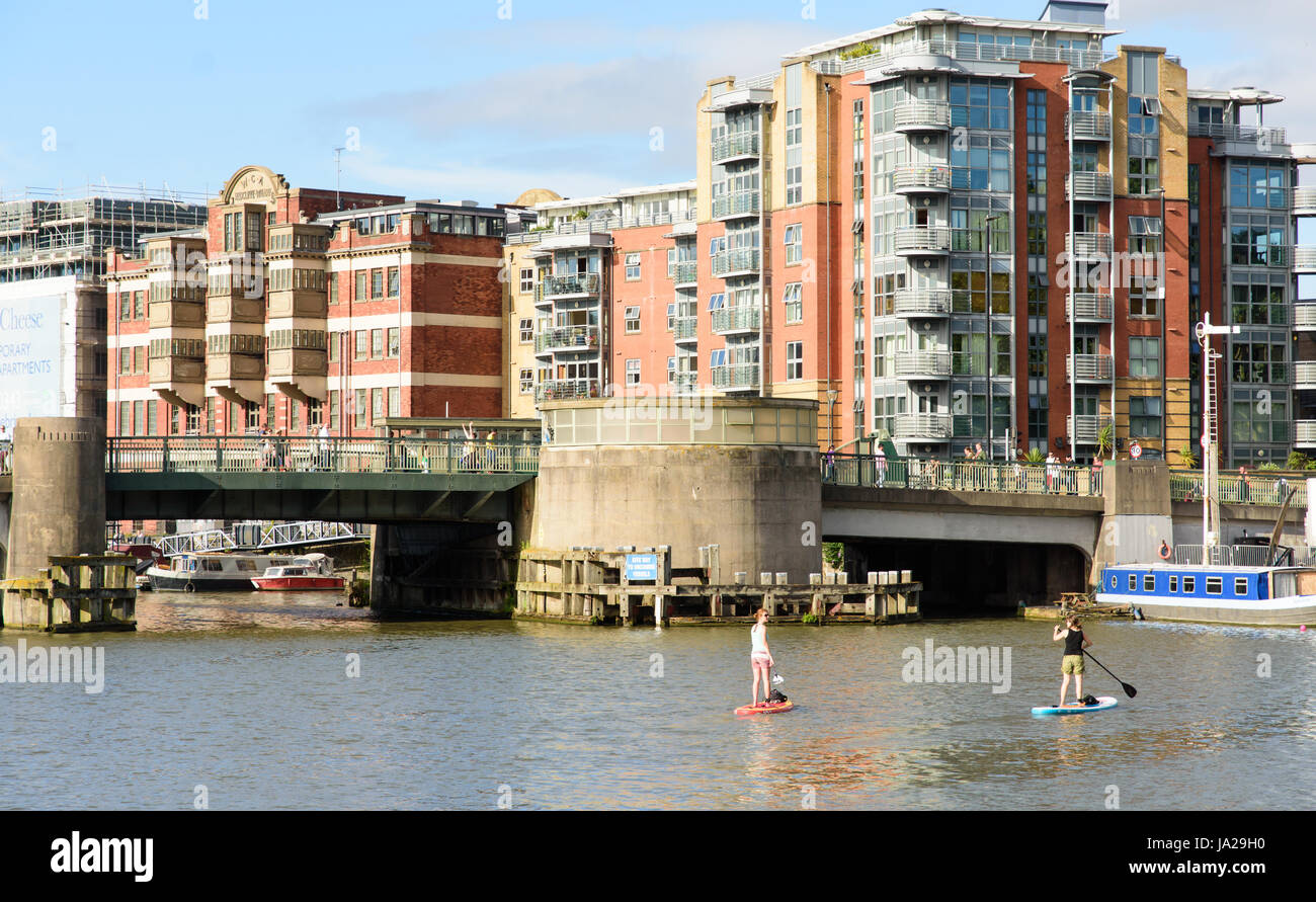 Bristol, England - July 17, 2016: Two women paddleboarding under Redcliffe Bridge on Bristol's Floating Harbour. Stock Photo