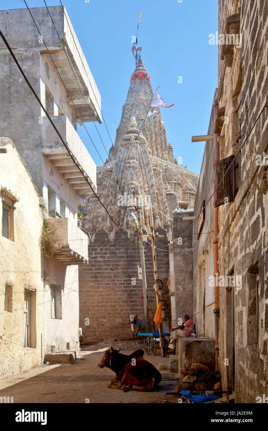 Gujarat, India - February 27, 2013: Vertical capture from one of the alleys around Shree Dwarakadheesh Krishna Temple in Dwarka showing a man climbing the steeple to change the colours of the flag. This is done frequently throught the day Stock Photo