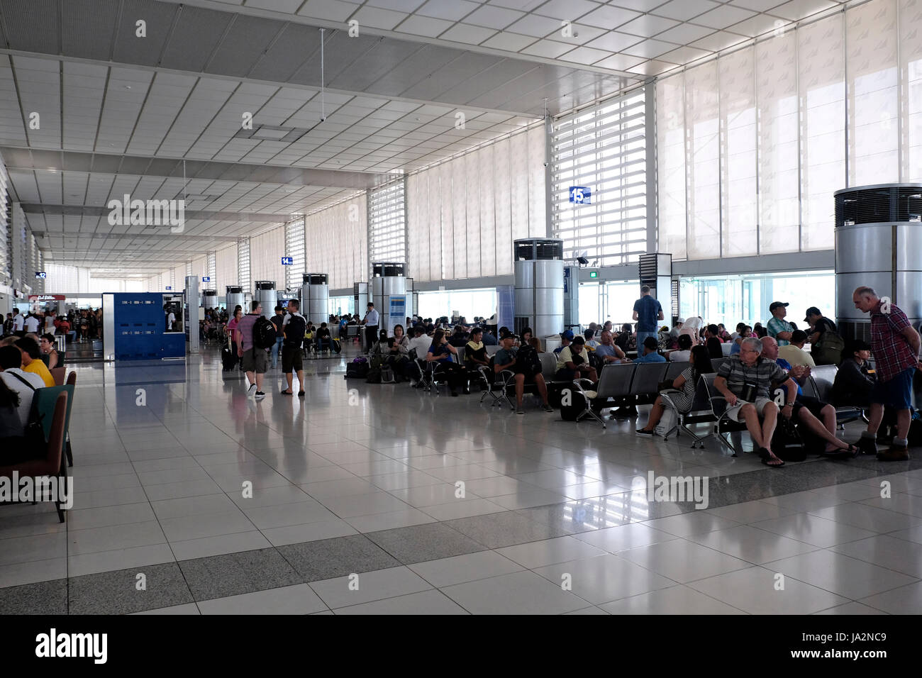 Passengers wait for their flight at the departure hall of terminal 3 of The Ninoy Aquino International Airport or NAIA, also known as Manila International Airport, Philippines Stock Photo