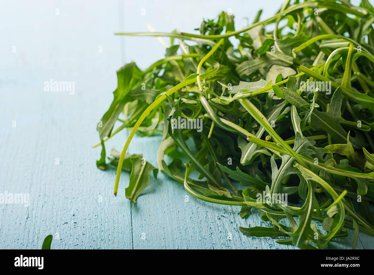Leaves of rucola on a blue board Stock Photo