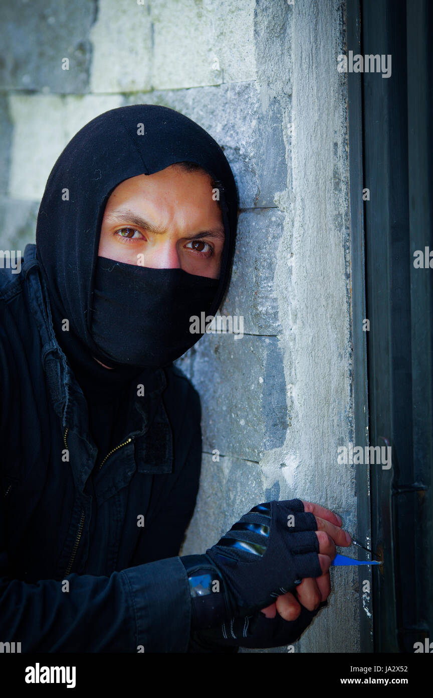 Man wearing balaclava and holding crowbar Stock Photo - Alamy
